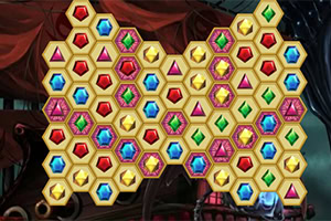 Pantalla de juego de rompecabezas con gemas hexagonales de colores formando una figura en forma de corazón sobre un fondo oscuro con cortinas rojas